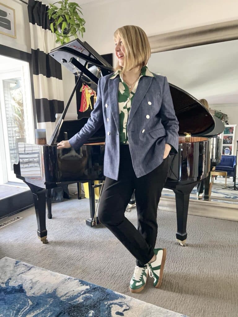 Woman wearing denim blazer, black, pants, and green and white sneakers modeling How to wear sneakers.