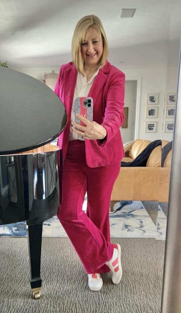 How to wear sneakers: woman wearing pink velveteen suit and pink striped sneakers.