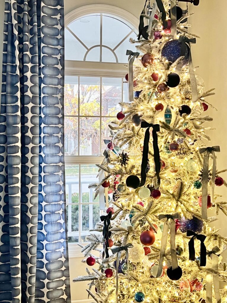 A white flocked Christmas tree decorated for a Christmas home tour.