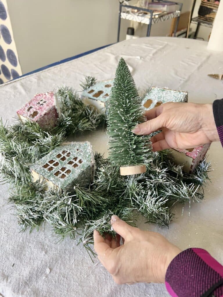 Gluing a green bottle brush tree into the Anthropologie DIY Christmas Wreath.