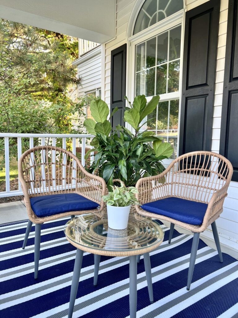 Two chairs and a table on a blue and white striped rug: front porch ideas