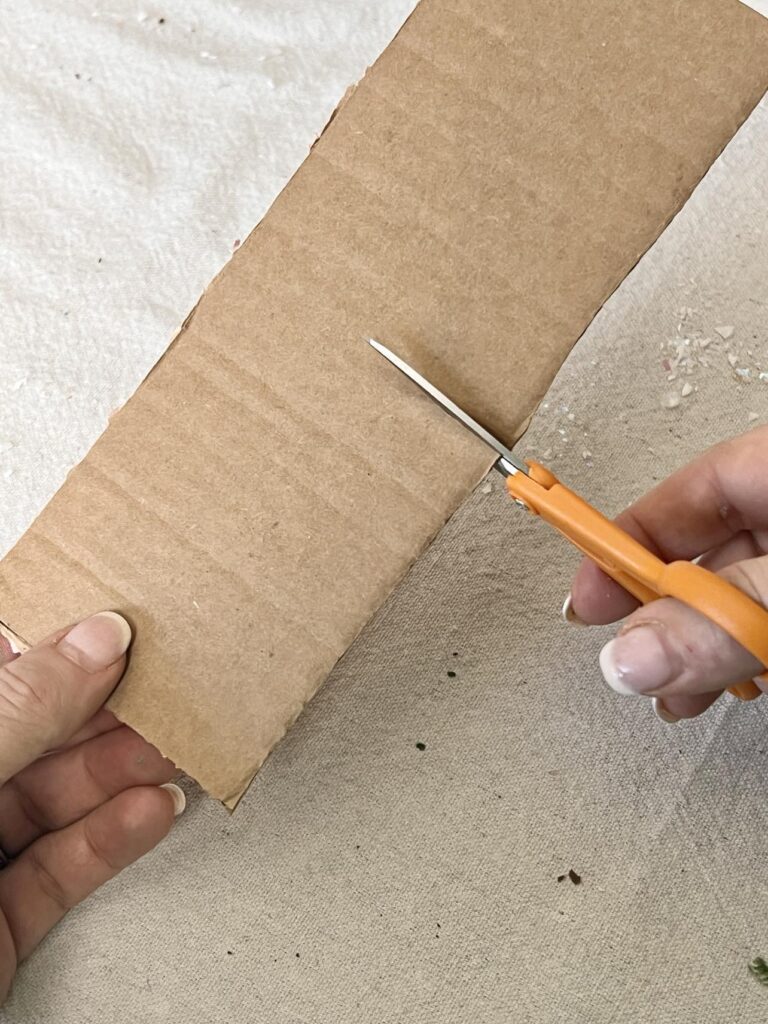 Cutting a piece of cardboard.