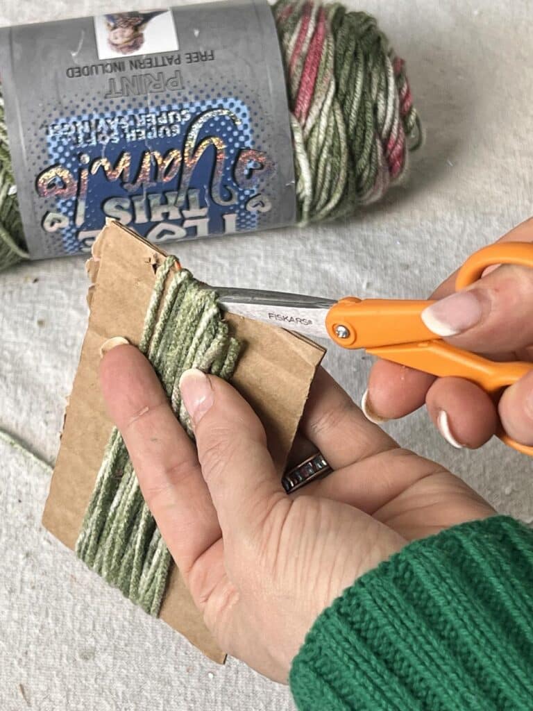 Cutting yarn with a pair of scissors.