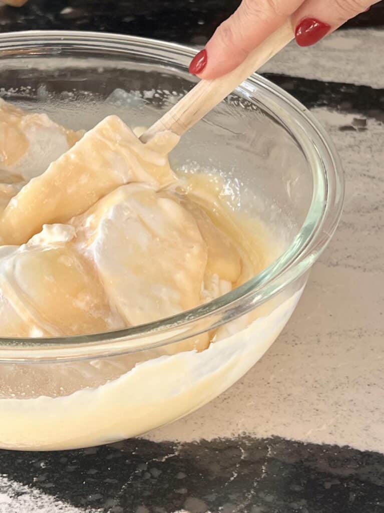 Folding whipped topping into cheesecake mixture.