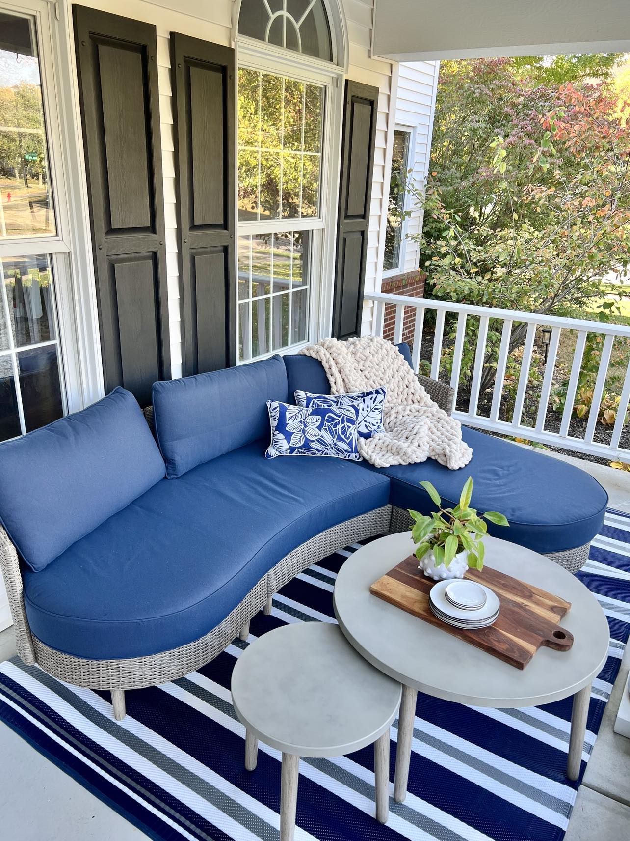 An outdoor sectional sofa on a front porch.