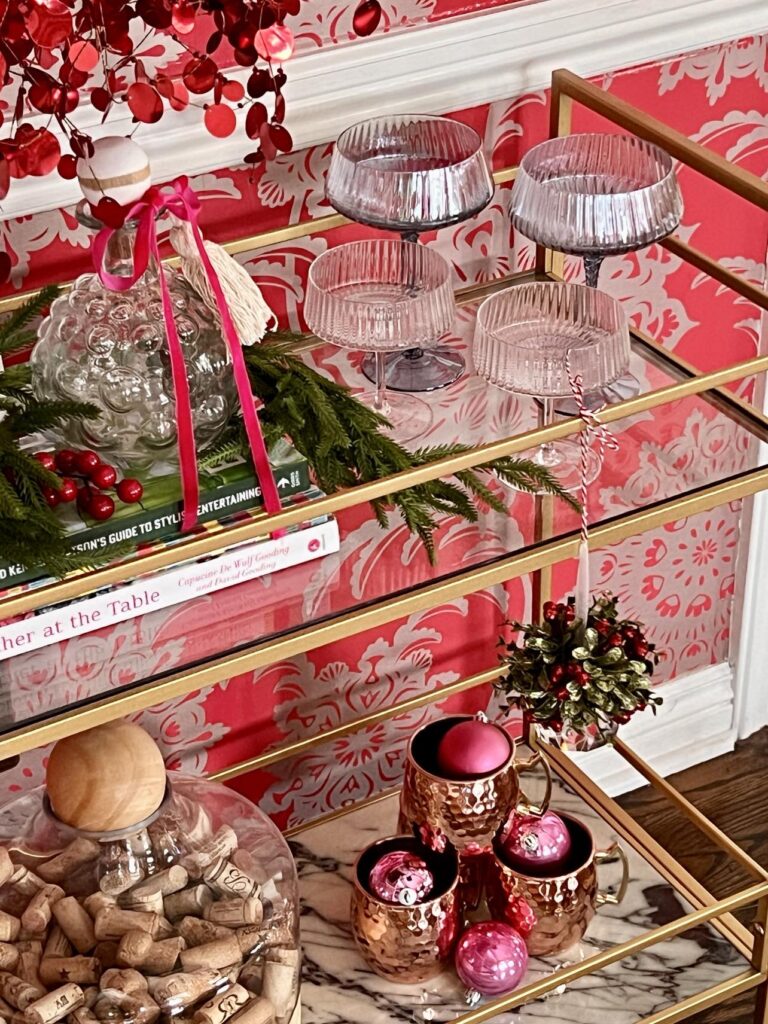 Coup glasses displayed on a bar cart for a holiday home tour.