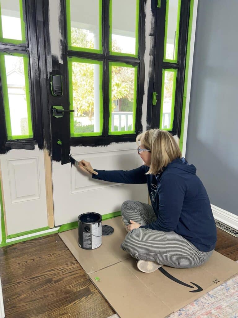 A woman painting a front porch door.