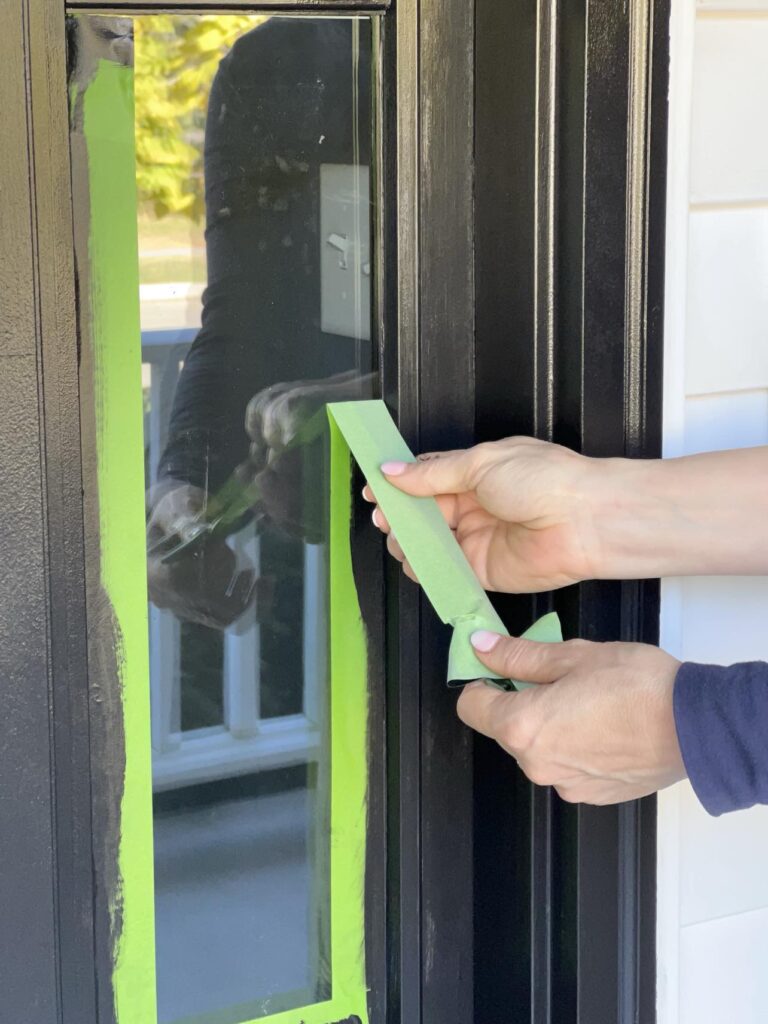 Pulling the painters tape away to reveal a freshly painted door for the front porch.