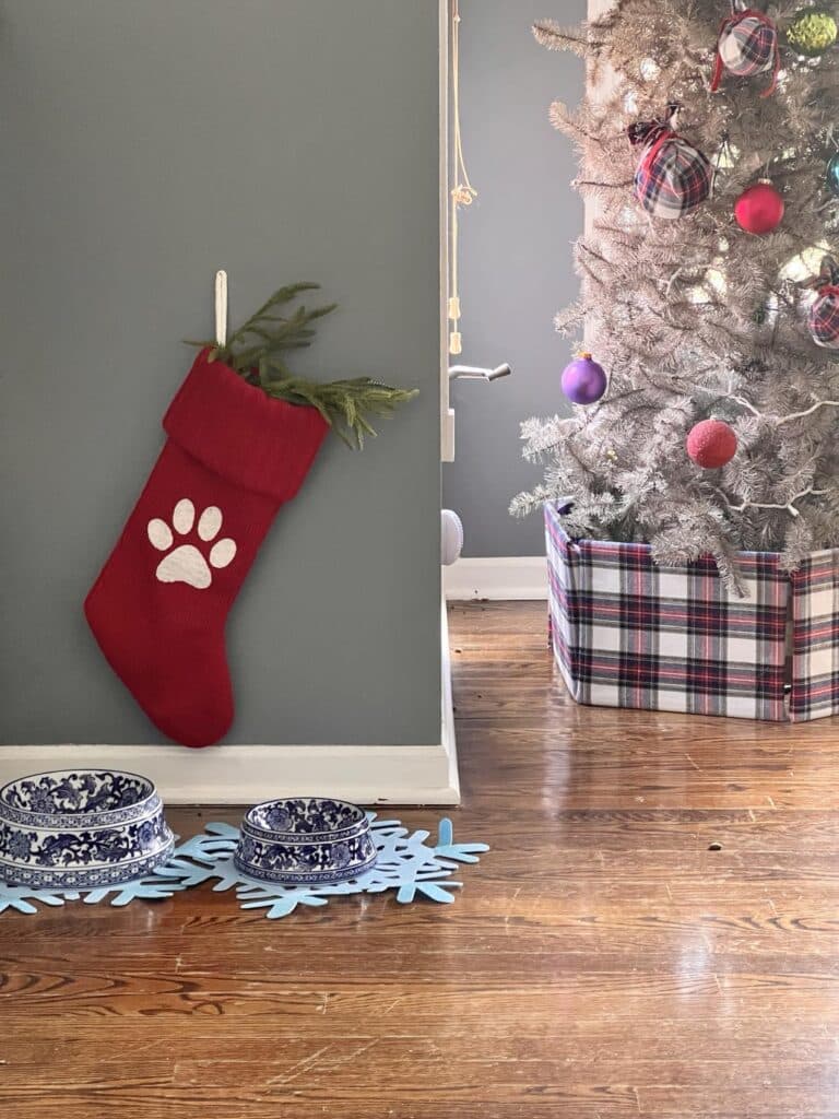 A red stocking hung above blue and white dog dishes.