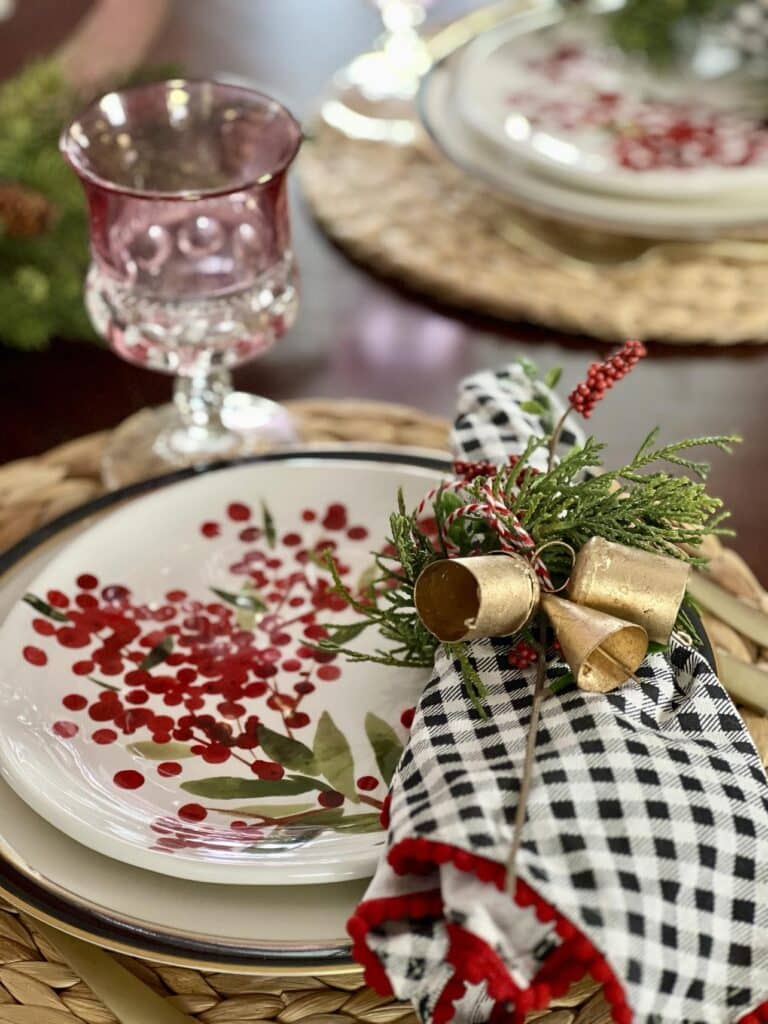 A black and white checked napkin on a plate with a red berry design.