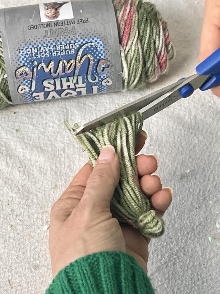 Trimming the ends of a Christmas tree tassel with scissors.