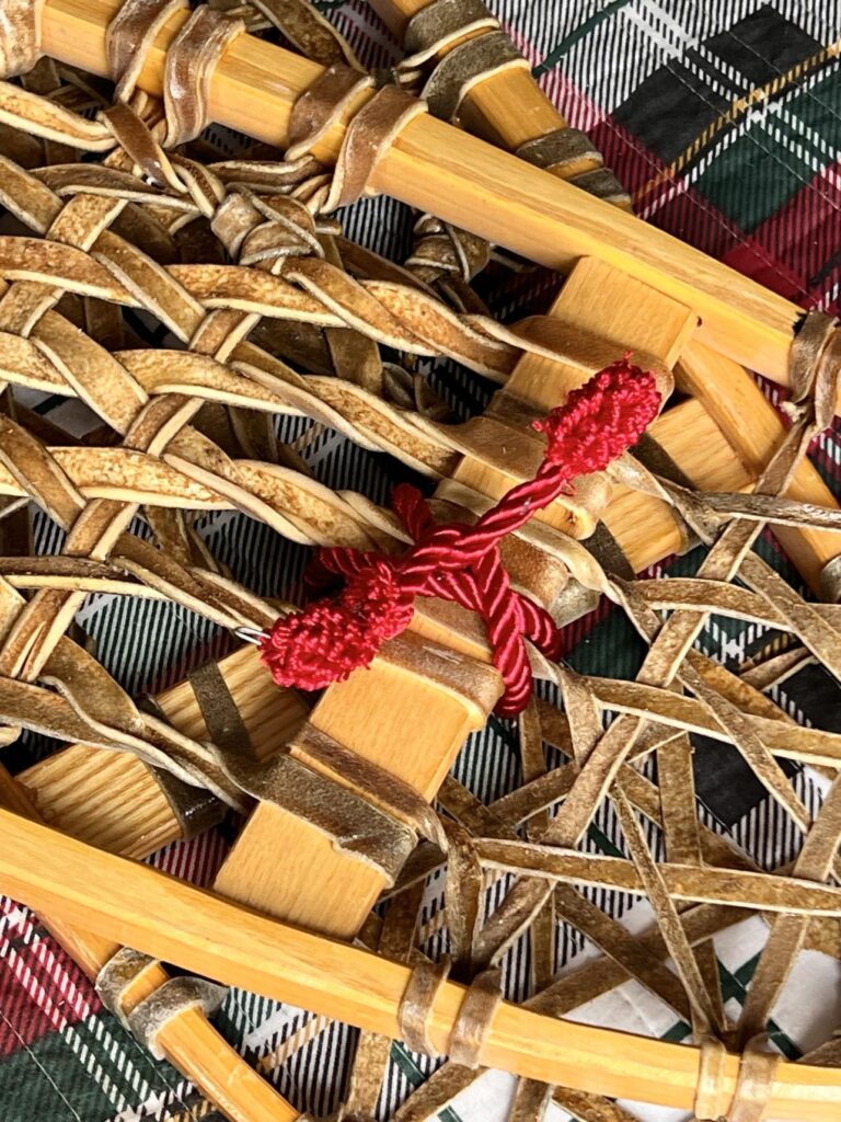 Two snowshoes bound together with a red twist tie for Decorating with snowshoes.