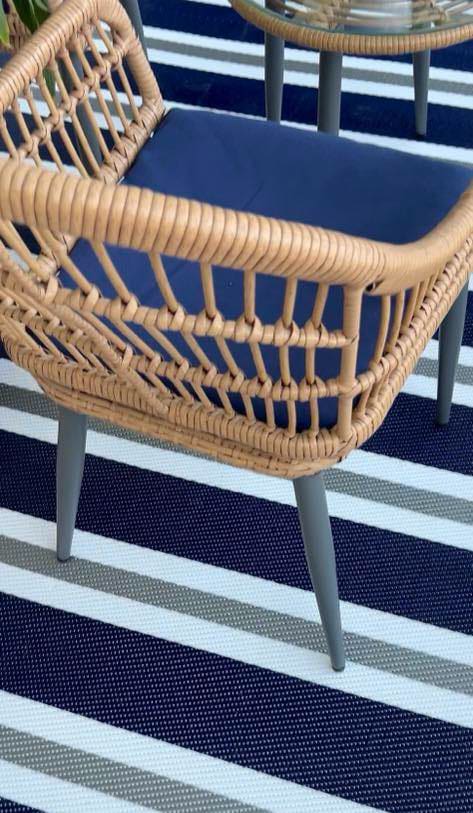 blue and white stripe rug under a wicker chair