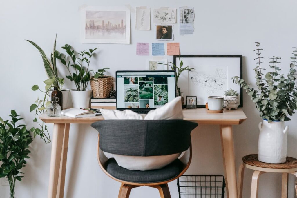 A bedroom desk decorated with plants and artwork.