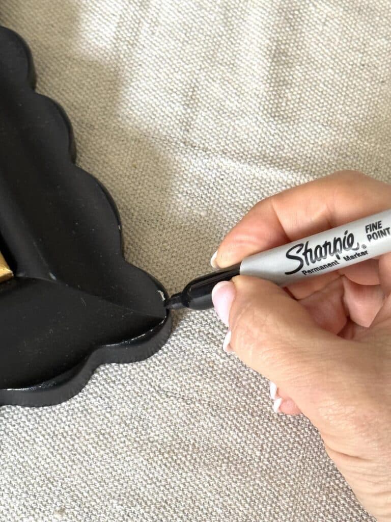 Covering a scratch on a frame with a black sharpie.