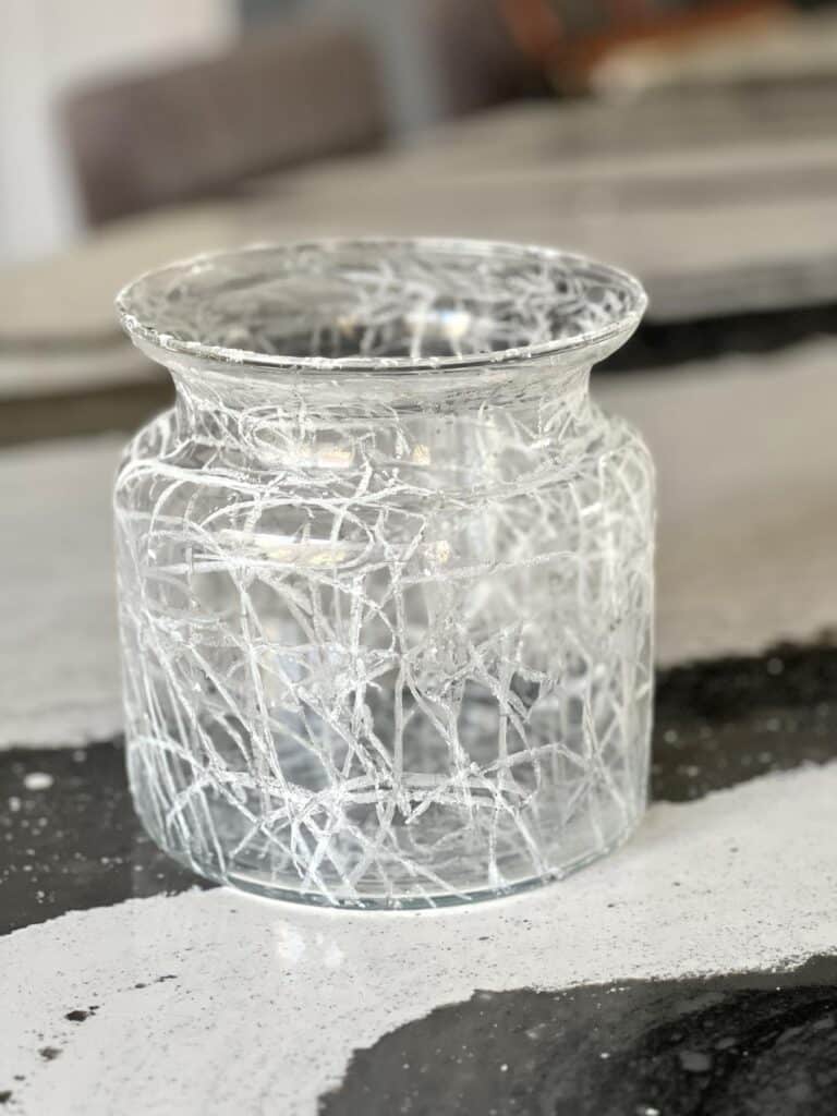 A glass vase with a crackled glass dIY effect.