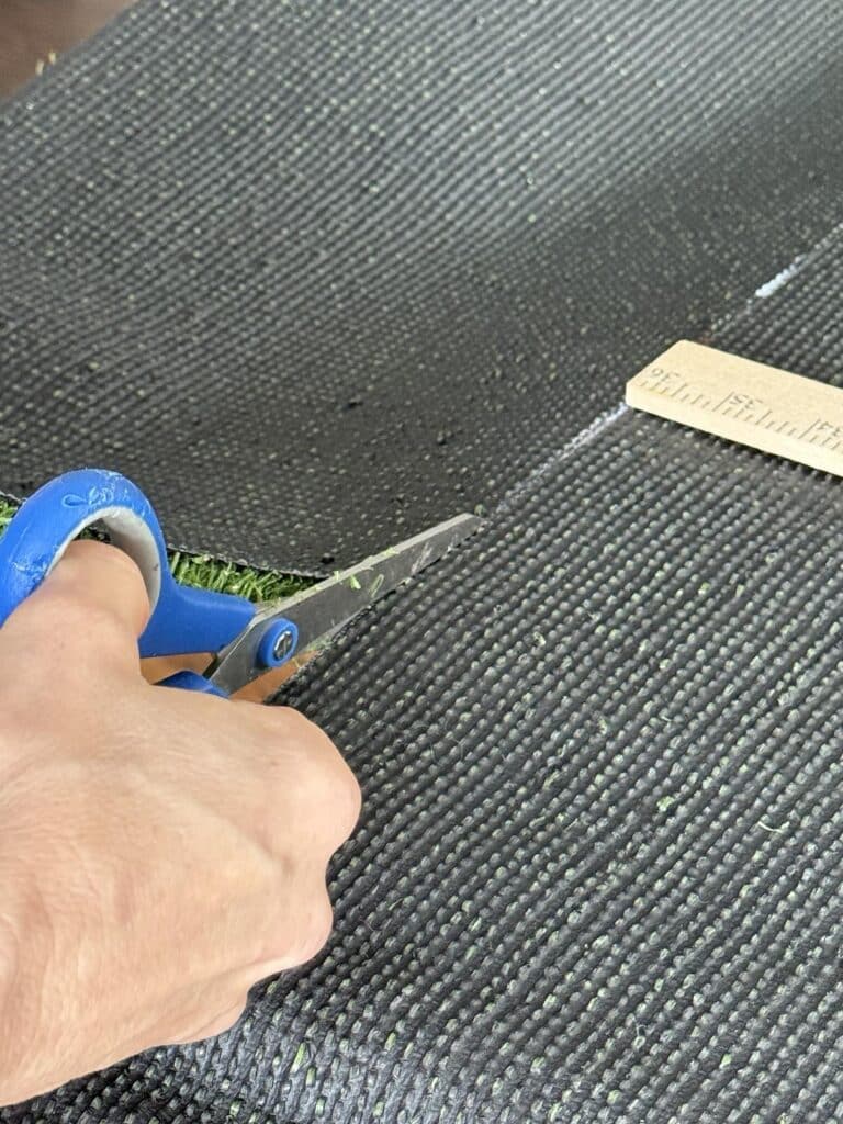 Cutting the Super Bowl table artificial grass.