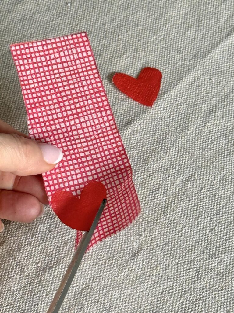 Cutting out a heart from a paper napkin.