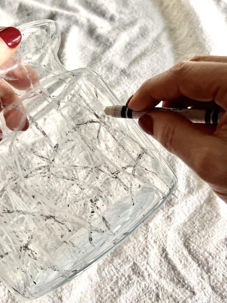 Drawing arches onto the side of glass vase using a white crayon.