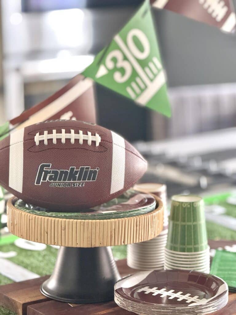 A football sitting on a pedestal on a DIY Super Bowl table.