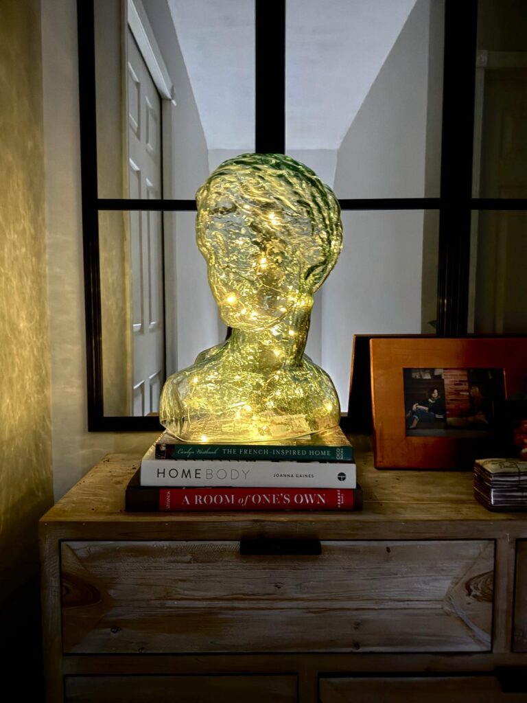 Fairy lights inside a glass head bust.