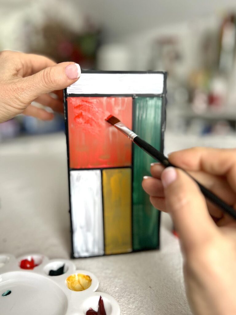 Painting primary colors on a glass vase.