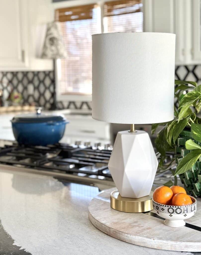 A small white kitchen lamp sitting on a kitchen island counter.