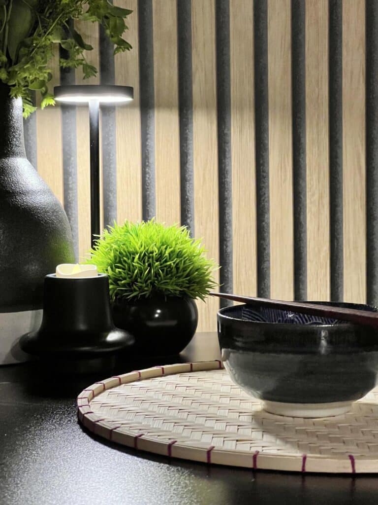 A wireless kitchen light on a counter with a bowl with chopsticks.