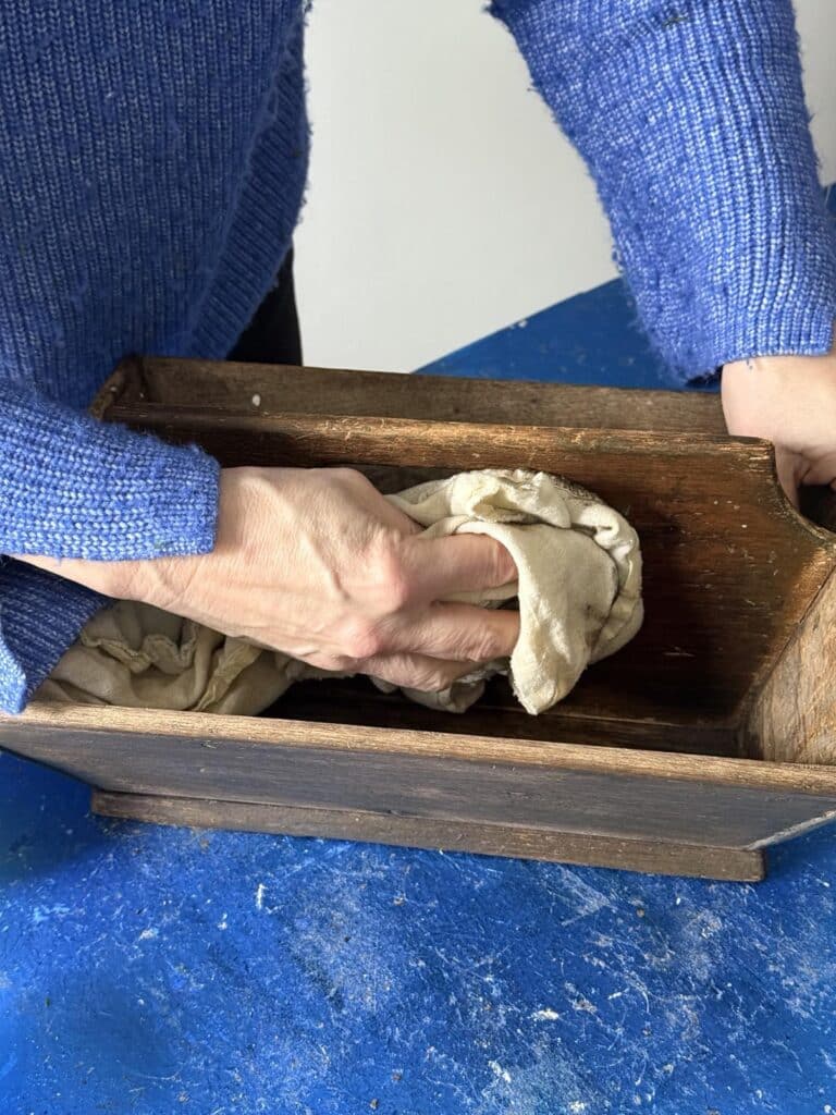 Buffing wax finish onto diy wood box centerpiece caddy.