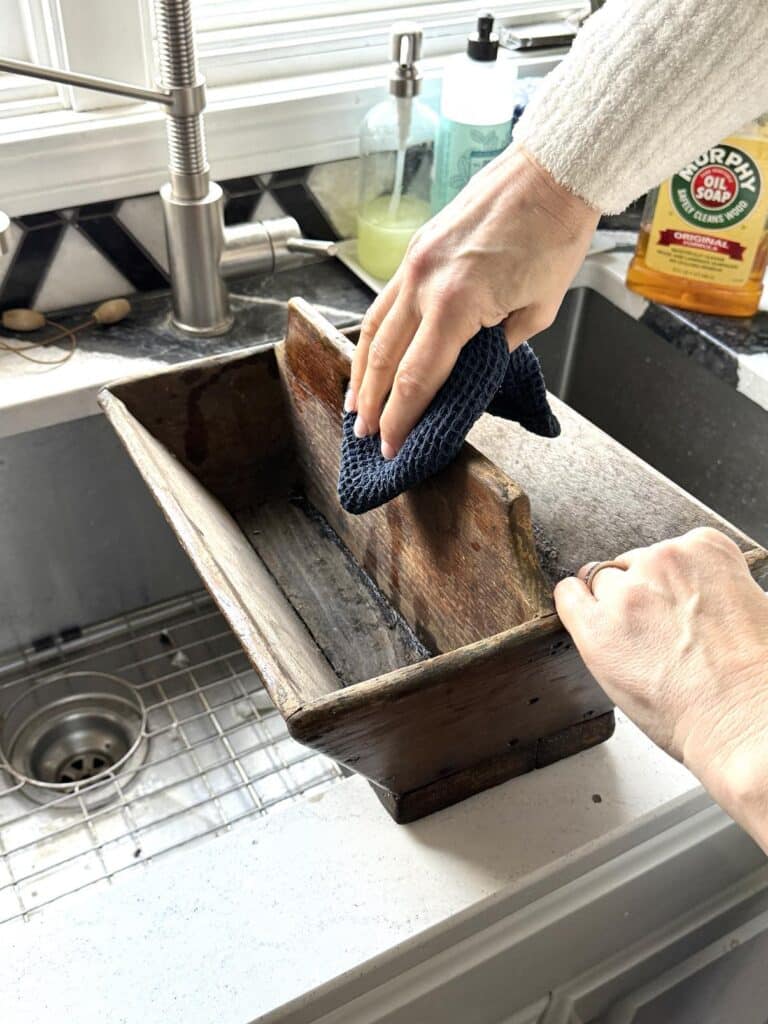 Cleaning a wood box in preparation for creating a DIY centerpiece.