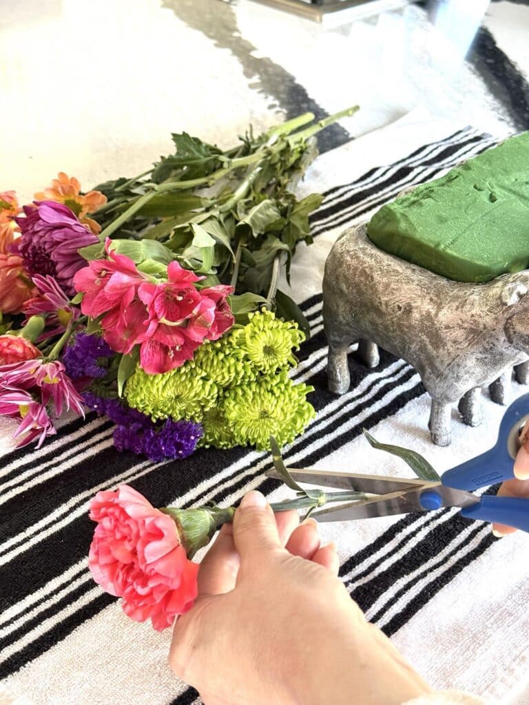 Trimming spring flowers for a centerpiece.