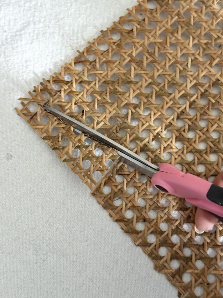 Cutting a piece of rattan with scissors.