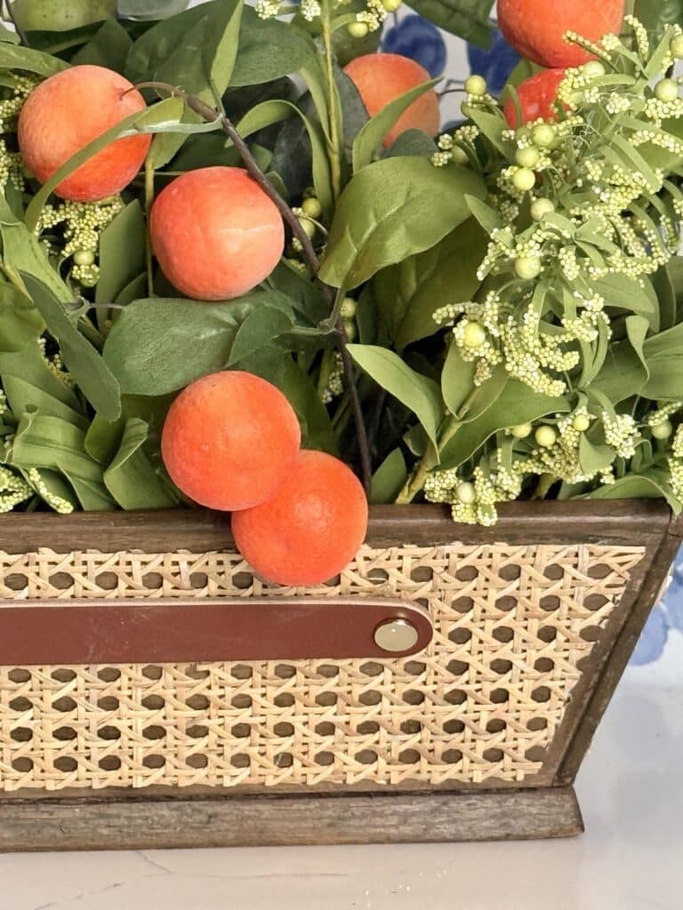 Faux greenery ad orange picks in a diy wood box centerpiece.