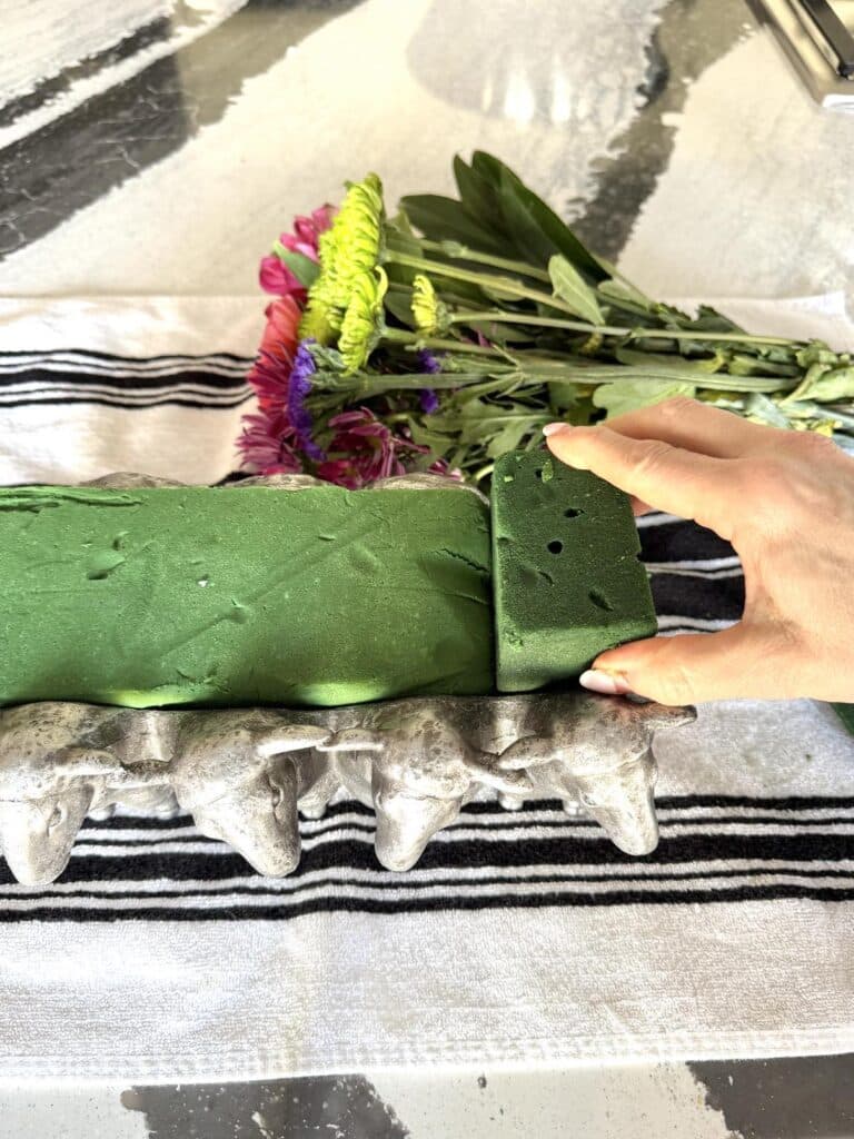 Placing florist foam in a container.