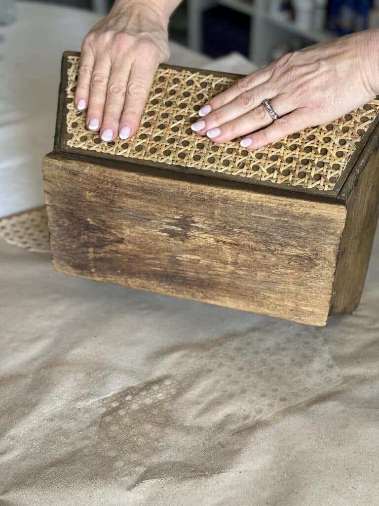 Placing a piece of rattan to the side of a diy wood box centerpiece.